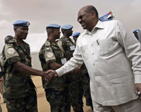 Le président Omar el-Béchir serre la main des casques bleus de la Mission des Nations unies et de l'Union africaine au Darfour, le 23&nbsp;juillet 2008.(Photo : Reuters)