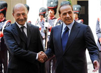 Malgré leur désaccord, Silvio Berlusconi et le président roumain Traian Basescu ont fait bonne figure devant les caméras en se serrant la main, assortie d'un sourire de circonstance.(Photo : AFP)