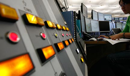 Une scientifique regarde des écrans d'ordinateurs au centre de contrôle du LHC du CERN à Genève.(Photo : Reuters)