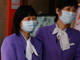 Des employés d'un restaurant chinois, chargés de l'accueil des clients, portent des masques de protection, près d'un hôtel où a séjourné le Mexicain testé positif au virus de la grippe A (H1N1), à Hong Kong, le 2 mai 2009.(Photo : Reuters)