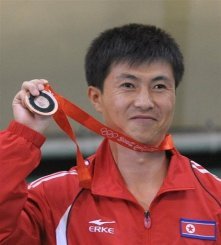 Le Nord-Coréen Kim Jong-su arbore sa médaille de bronze du tir au pistolet à 10m des JO de Pékin, le 9 août 2008