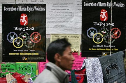  Dans les rues de Dharamsala, un Tibétain marche devant des posters condamnant les JO de Pékin 2008.(Photo : AFP)